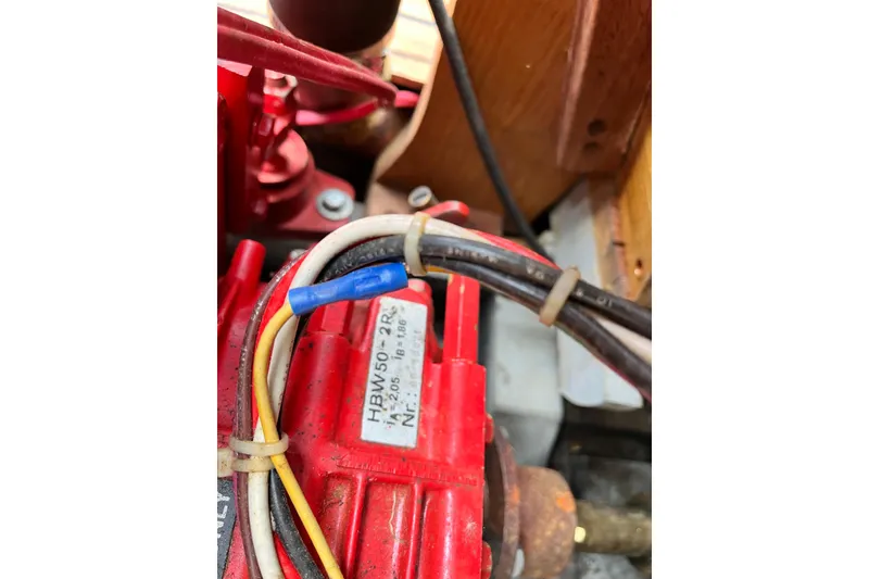 Slide: The Image of Close-up of a 1908 Outing launch engine component with visible wiring and label. - 15