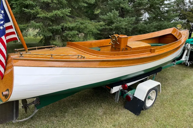 Slide: The Image of Vintage 1908 Outing launch boat on trailer, featuring wooden deck and American flag. - 4