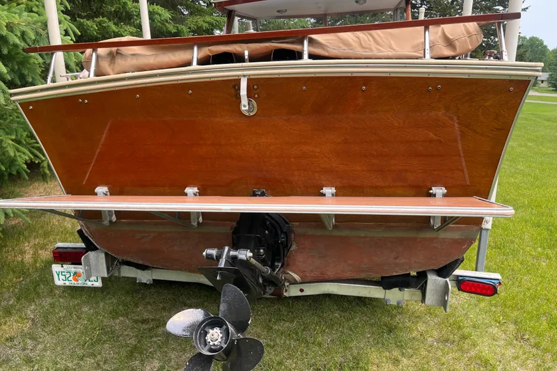 Slide: The Image of 1979 Skiff Craft 24 Flybridge boat on trailer, showcasing wooden stern and propeller. - 13