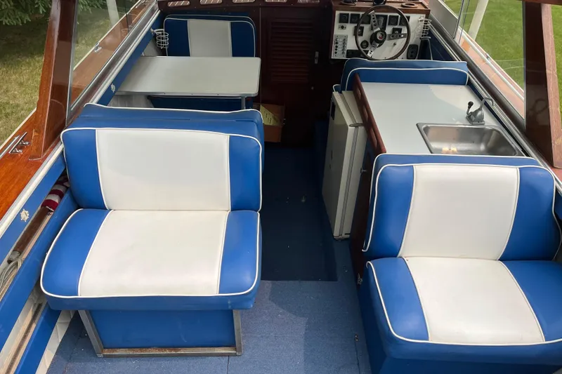 Slide: The Image of 1979 Skiff Craft 24 Flybridge interior with blue and white seating, table, and helm. - 15
