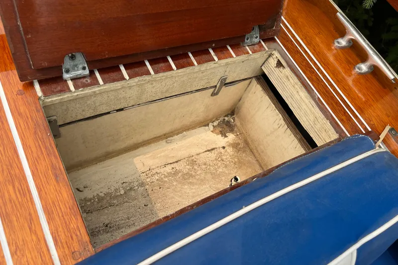 Slide: The Image of Open storage compartment on 1979 Skiff Craft 24 Flybridge boat with wooden and blue details. - 24