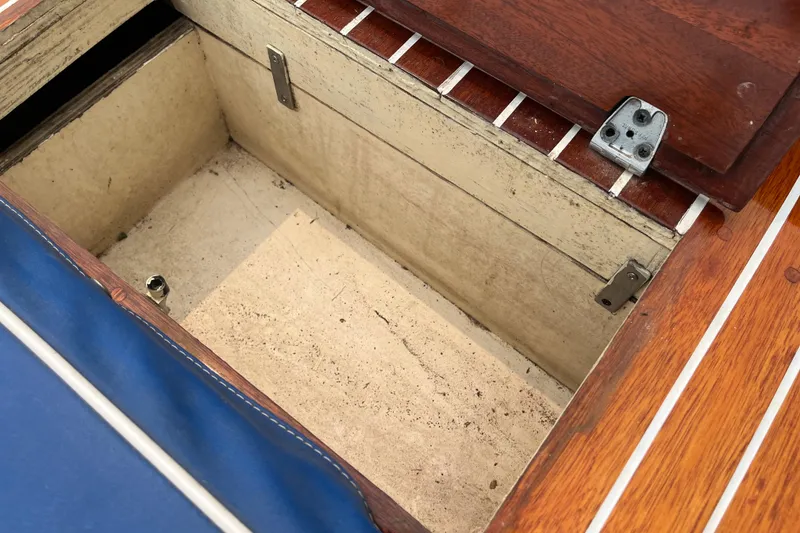Slide: The Image of Open storage compartment on 1979 Skiff Craft 24 Flybridge boat with wooden and blue details. - 25