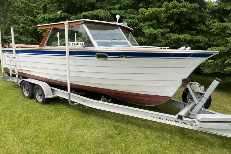 Slide: The Image of 1979 Skiff Craft 24 Flybridge boat on trailer, parked on grass. - 3