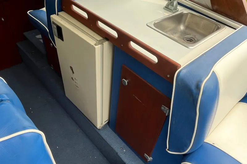 Slide: The Image of 1979 Skiff Craft 24 Flybridge interior with sink, fridge, and blue seating. - 30