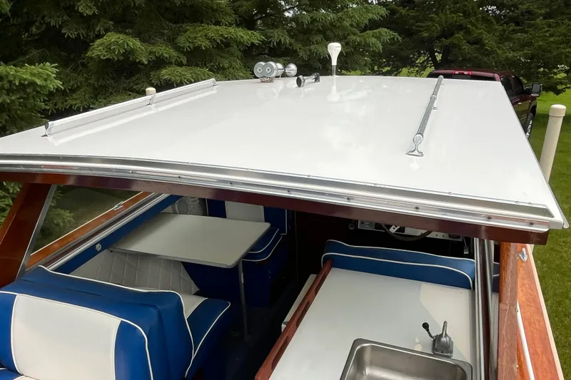 Slide: The Image of 1979 Skiff Craft 24 Flybridge boat interior with blue and white seating, sink, and table. - 31