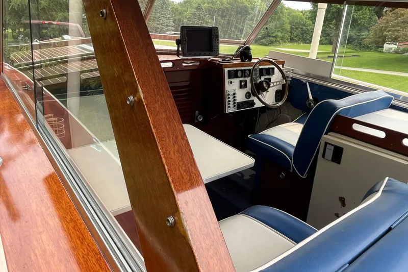 Slide: The Image of Interior of a 1979 Skiff Craft 24 Flybridge boat with wood and blue seating. - 35