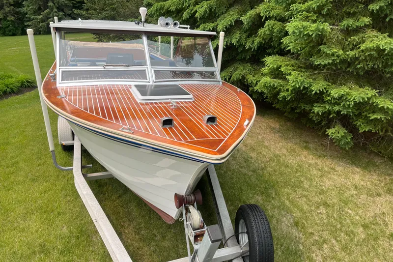 Slide: The Image of 1979 Skiff Craft 24 Flybridge boat on trailer, surrounded by lush greenery. - 7