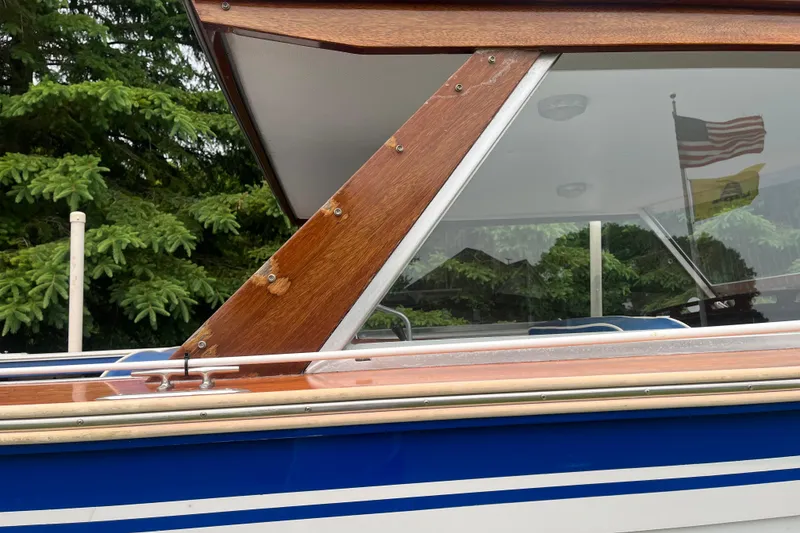 Slide: The Image of 1979 Skiff Craft 24 Flybridge boat with wooden trim and blue accents. - 9