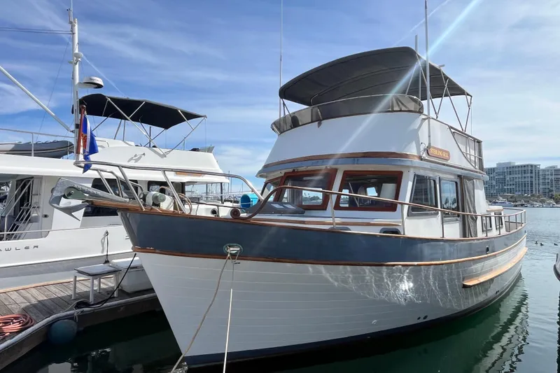 The Image of 1978 Marine Trader 40 yacht docked at marina under clear blue sky. - 0