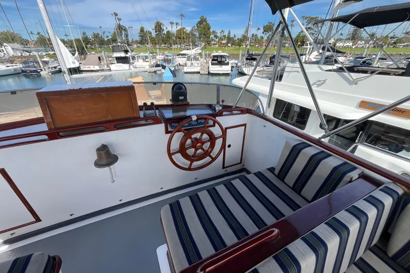 Slide: The Image of 1978 Marine Trader 40 boat helm with striped seating, docked in a marina. - 12