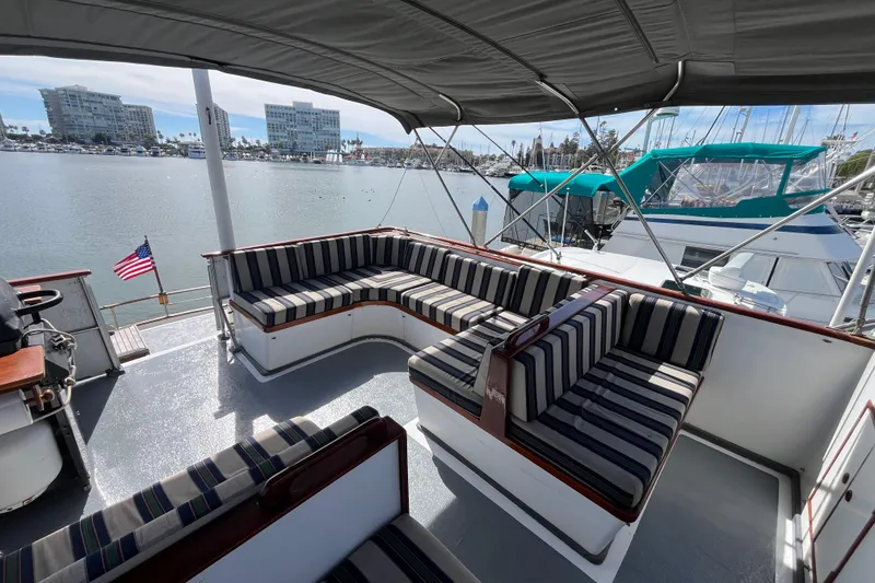 Slide: The Image of 1978 Marine Trader 40 yacht with striped seating, docked in a marina with waterfront view. - 13