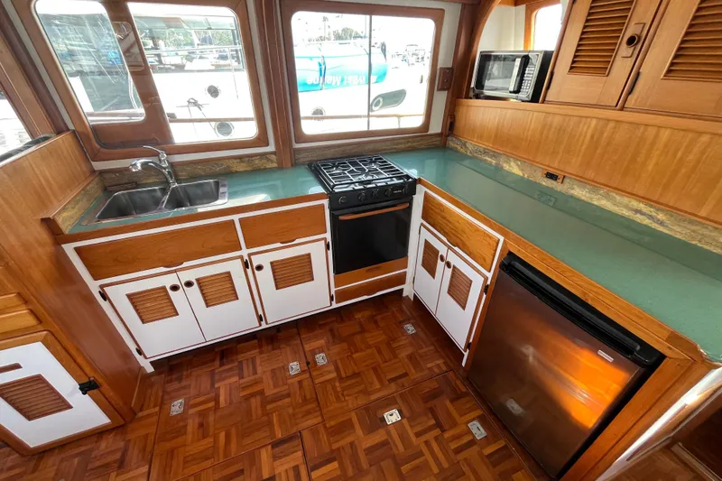 Slide: The Image of 1978 Marine Trader 40 yacht kitchen with wood cabinetry, stove, sink, and refrigerator. - 19