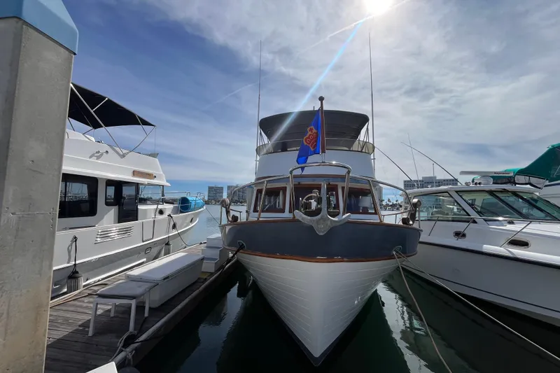Slide: The Image of 1978 Marine Trader 40 yacht docked between two boats under a sunny sky. - 2