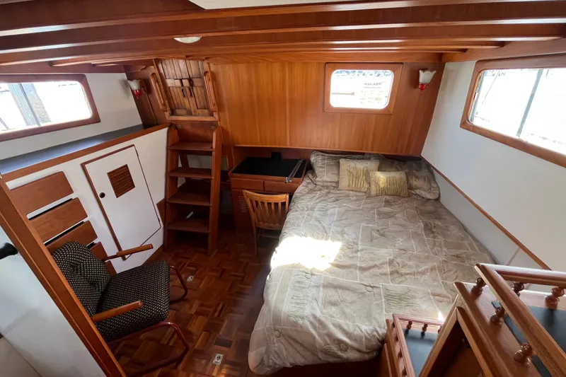 Slide: The Image of 1978 Marine Trader 40 cabin interior with bed, chair, and wooden furnishings. - 25