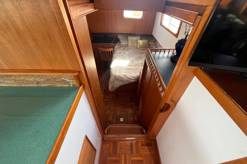 Slide: The Image of Interior of 1978 Marine Trader 40 yacht with wooden furnishings and cozy sleeping area. - 29