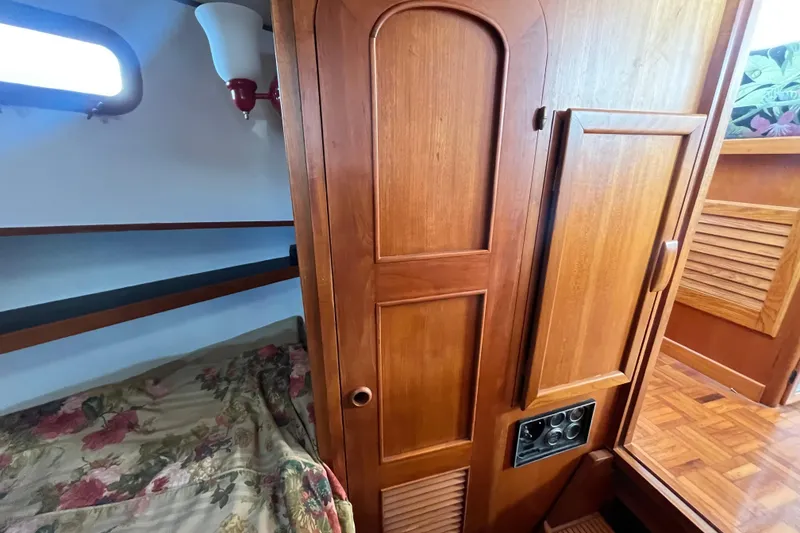 Slide: The Image of 1978 Marine Trader 40 interior with wooden cabinetry and floral bedding. - 32