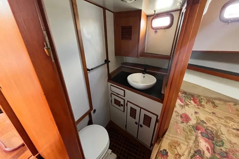 Slide: The Image of 1978 Marine Trader 40 interior with bathroom and floral bedding. - 33
