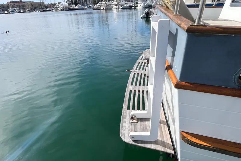 Slide: The Image of 1978 Marine Trader 40 yacht with wooden swim platform in a marina setting. - 4