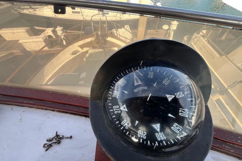 Slide: The Image of Compass on 1978 Marine Trader 40 boat, with deck reflection and scattered screws. - 43