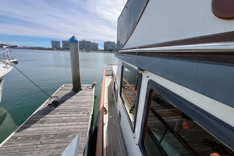 Slide: The Image of 1978 Marine Trader 40 yacht docked at a marina with waterfront buildings in the background. - 8