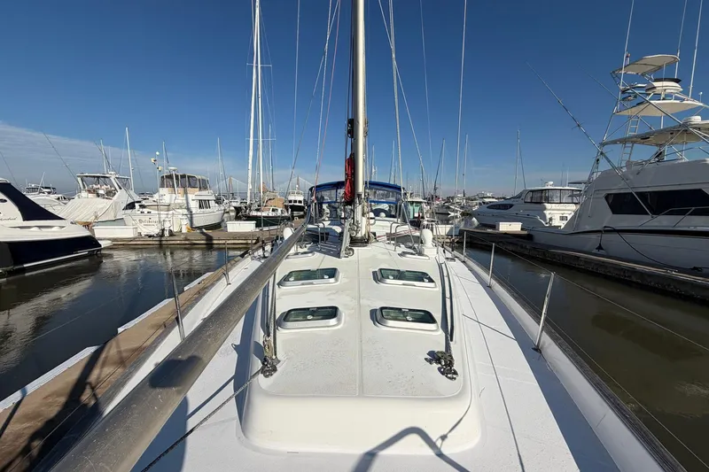 Slide: The Image of 2004 Beneteau 57 yacht docked in marina, surrounded by other boats under clear blue sky. - 15