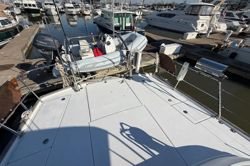 Slide: The Image of Beneteau 57 yacht deck with dinghy and Yamaha motor, docked at marina, 2004 model. - 24