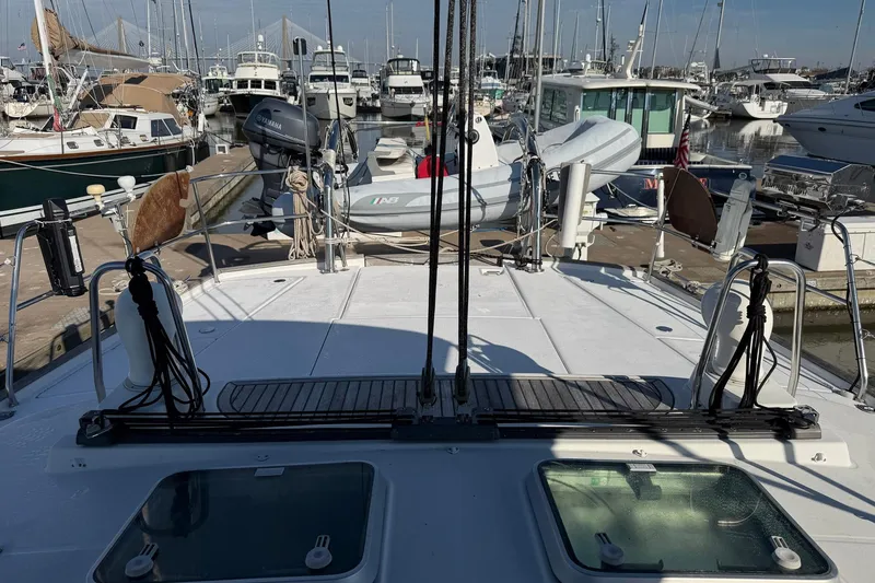 Slide: The Image of 2004 Beneteau 57 yacht docked at marina with dinghy and other boats. - 26