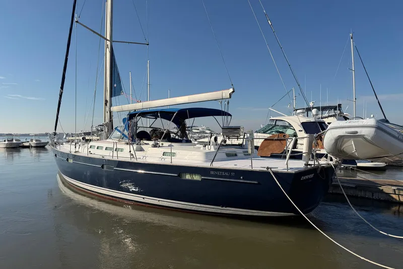 Slide: The Image of 2004 Beneteau 57 sailboat docked at marina under clear blue sky. - 3