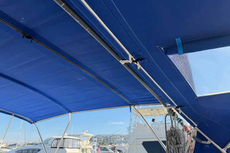 Slide: The Image of Blue canopy on a 2004 Beneteau 57 sailboat, docked at a marina. - 34