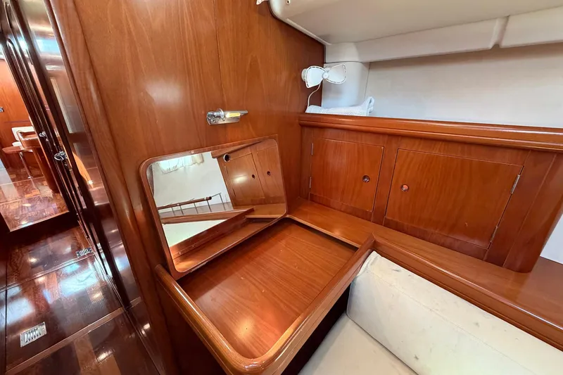 Slide: The Image of Luxurious wooden interior of 2004 Beneteau 57 yacht with mirror and storage cabinets. - 58