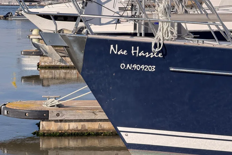 Slide: The Image of Beneteau 57 sailboat, 2004 model, docked with visible name "Nae Hassle" and registration number. - 7