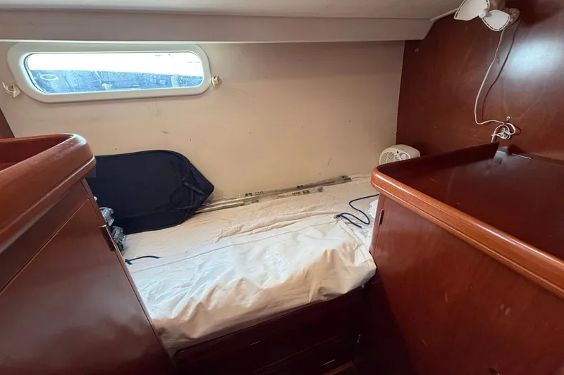 Slide: The Image of 2004 Beneteau 57 yacht cabin interior with wooden furnishings and a small bed. - 72