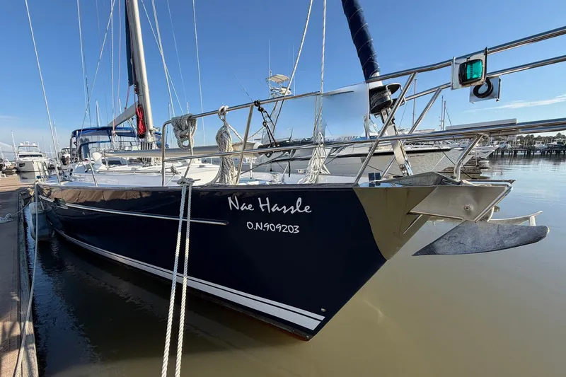 Slide: The Image of 2004 Beneteau 57 sailboat docked, featuring sleek design and nautical equipment. - 8