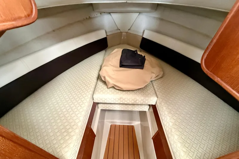 Slide: The Image of 2017 Ranger Tugs R-25 cabin interior with cushioned seating and wooden accents. - 10