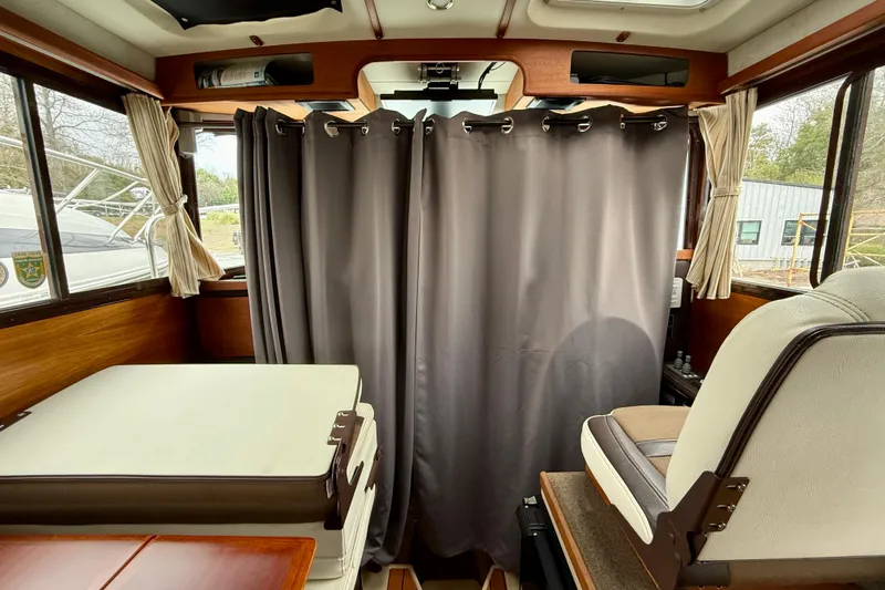 Slide: The Image of Interior of a 2017 Ranger Tugs R-25 boat with seating and curtains. - 12
