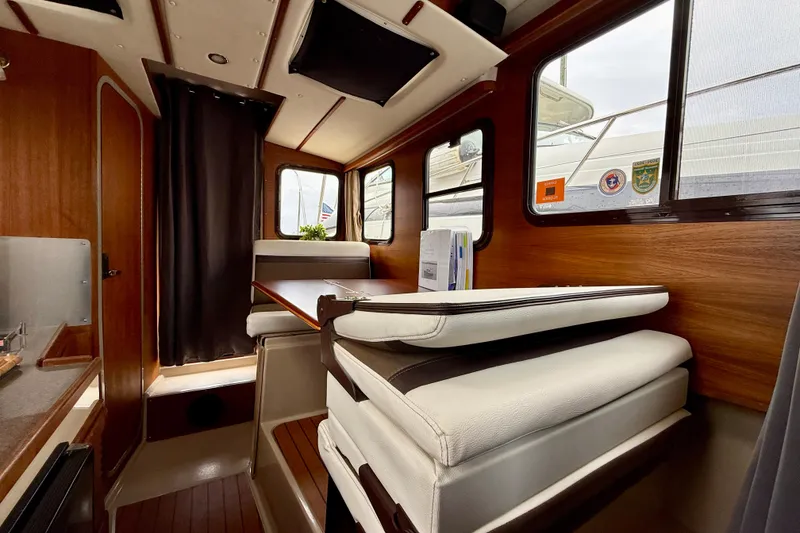 Slide: The Image of Interior of 2017 Ranger Tugs R-25 boat with wood paneling and cushioned seating. - 14