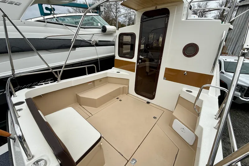 Slide: The Image of 2017 Ranger Tugs R-25 boat deck with seating and cabin entrance. - 16