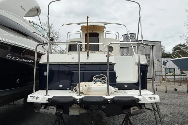 Slide: The Image of 2017 Ranger Tugs R-25 boat docked, rear view with metal railings and equipment. - 18