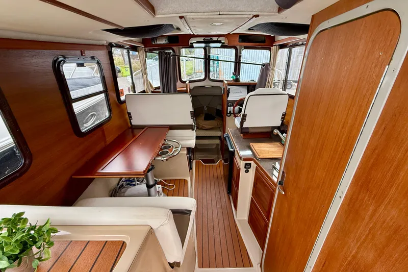 Slide: The Image of 2017 Ranger Tugs R-25 interior with wood accents and seating area. - 3