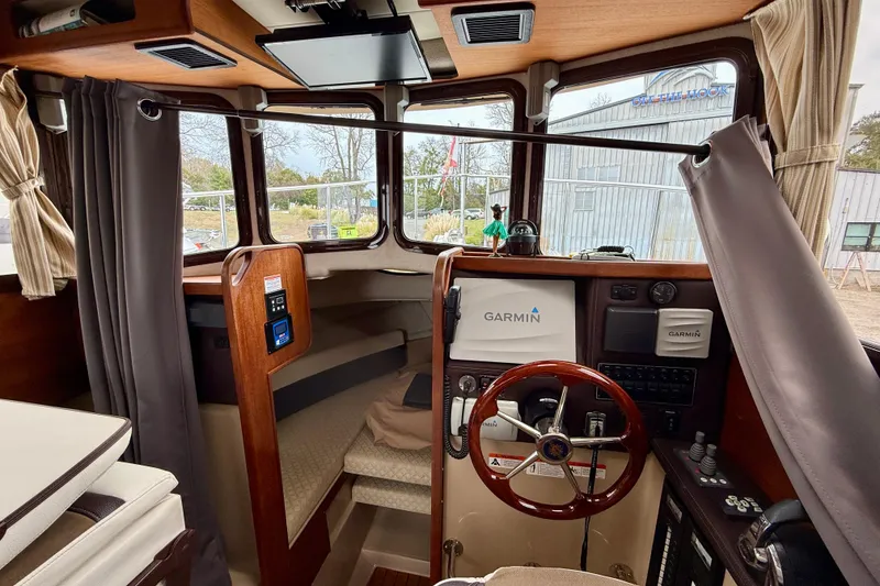 Slide: The Image of 2017 Ranger Tugs R-25 boat interior with Garmin navigation system and wooden steering wheel. - 9