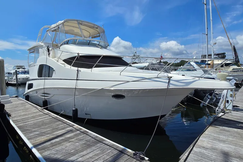The Image of 2003 Silverton 392 Motor Yacht docked at marina under clear blue sky. - 1