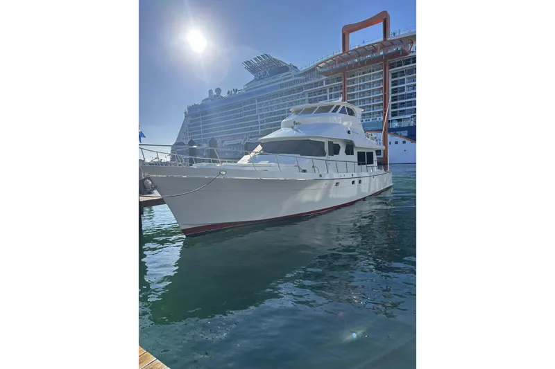 The Image of 2006 North Star Yachts 73 Cockpit Motoryacht docked beside a large cruise ship. - 0