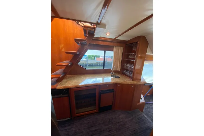 Slide: The Image of Luxurious interior of 2006 North Star Yachts 73 Cockpit Motoryacht with wooden cabinetry and bar area. - 19