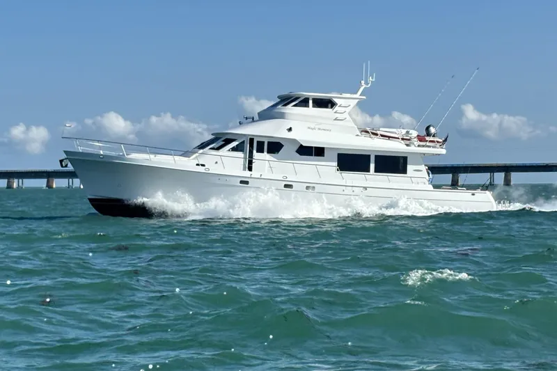 Slide: The Image of 2006 Northstar 73 Cockpit Motoryacht cruising on open water, bridge in background. - 2