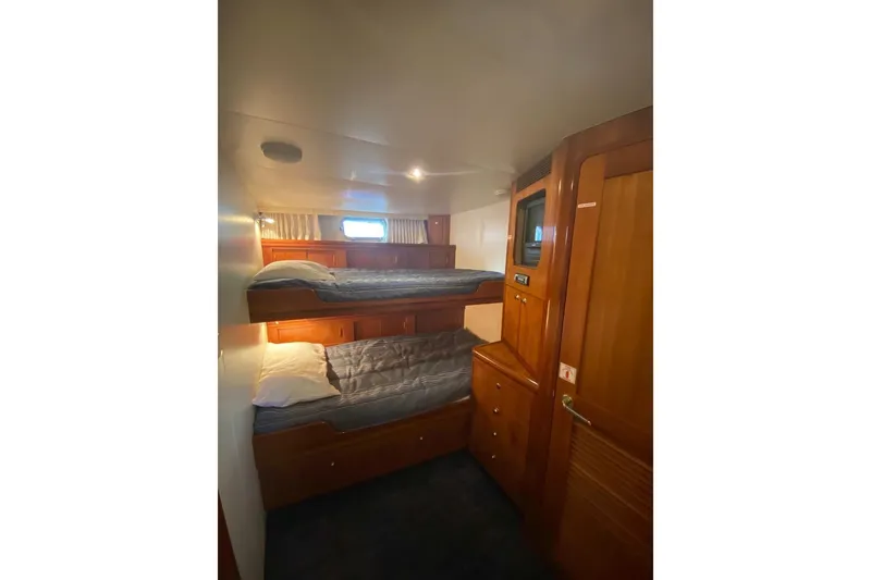 Slide: The Image of Interior of 2006 North Star Yachts 73 Cockpit Motoryacht with cozy bunk beds and wooden cabinetry. - 25