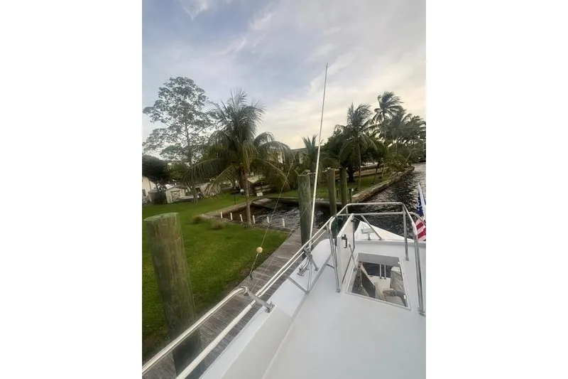 Slide: The Image of 2006 North Star Yachts 73 Cockpit Motoryacht docked near palm trees and waterfront. - 51