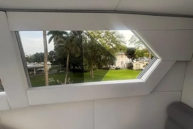Slide: The Image of Interior view from 2006 North Star Yachts 73 Cockpit Motoryacht window, showcasing lush greenery outside. - 62