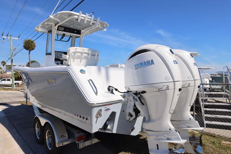 Slide: The Image of 2026 Sea Hunt Gamefish 25 boat with dual Yamaha engines on a trailer. - 10