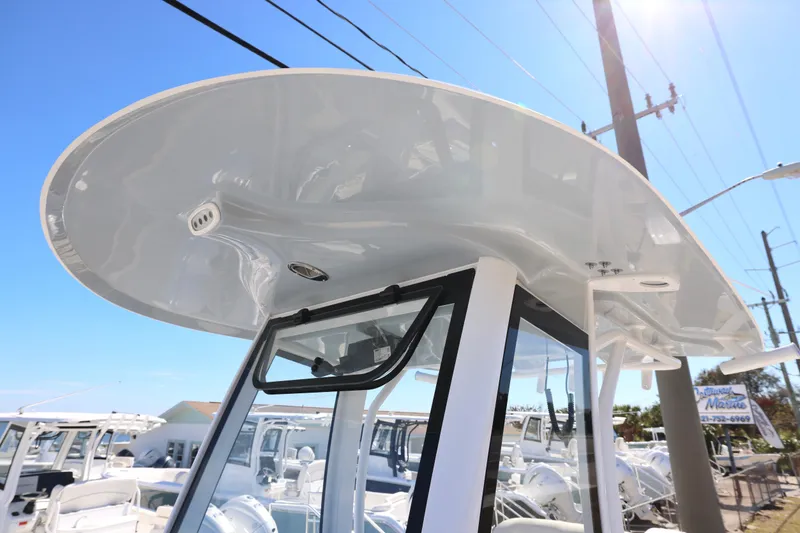 Slide: The Image of 2026 Sea Hunt Gamefish 25 boat with sleek T-top design under clear blue sky. - 11