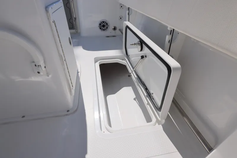 Slide: The Image of 2026 Sea Hunt Gamefish 25 boat storage compartment with open hatch, showcasing interior space. - 14